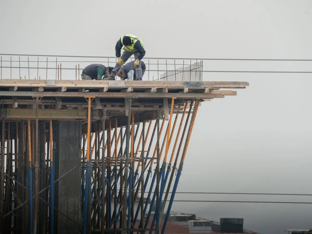 Trabajadores ejecutando una losa en altura en un edificio en construcción